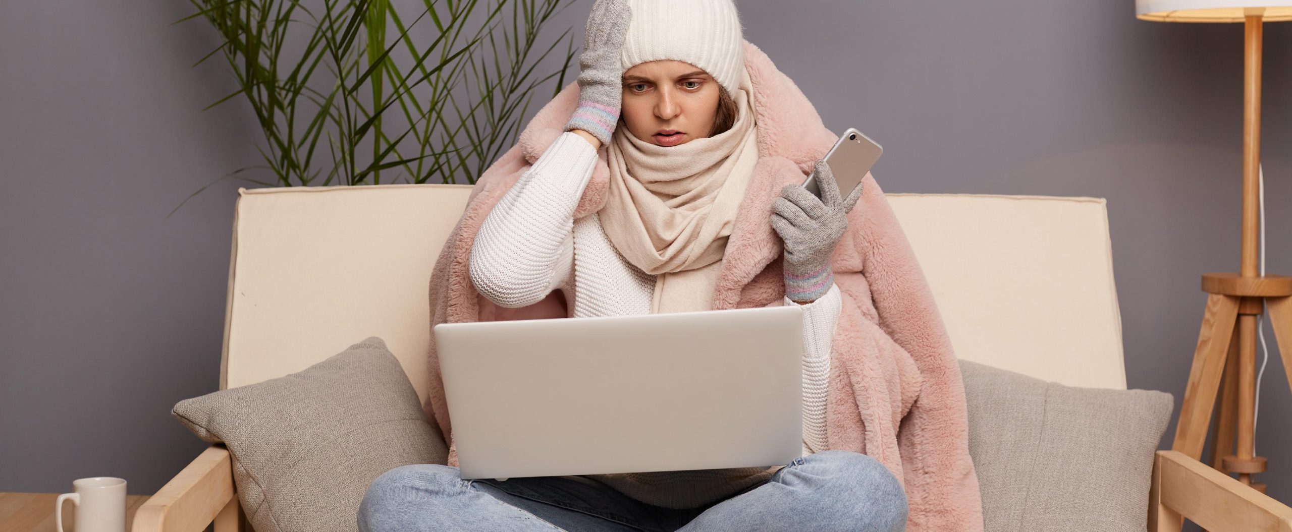 woman with hat and blanket on with laptop on lap