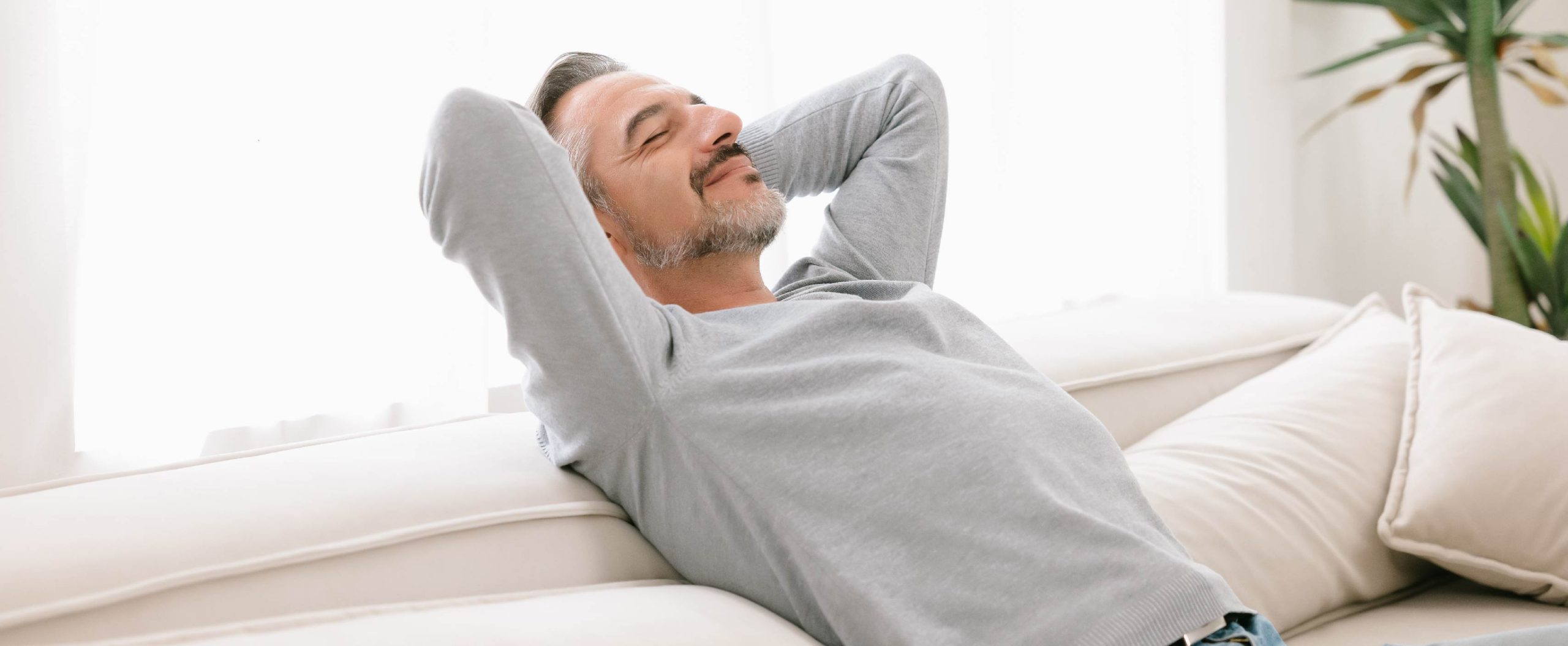 man sitting on sofa relaxing in home comfort